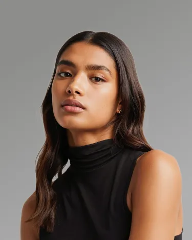 A woman wearing a black turtle neck top.
