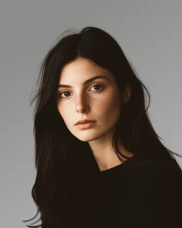 A woman with long dark hair is posing for a picture.